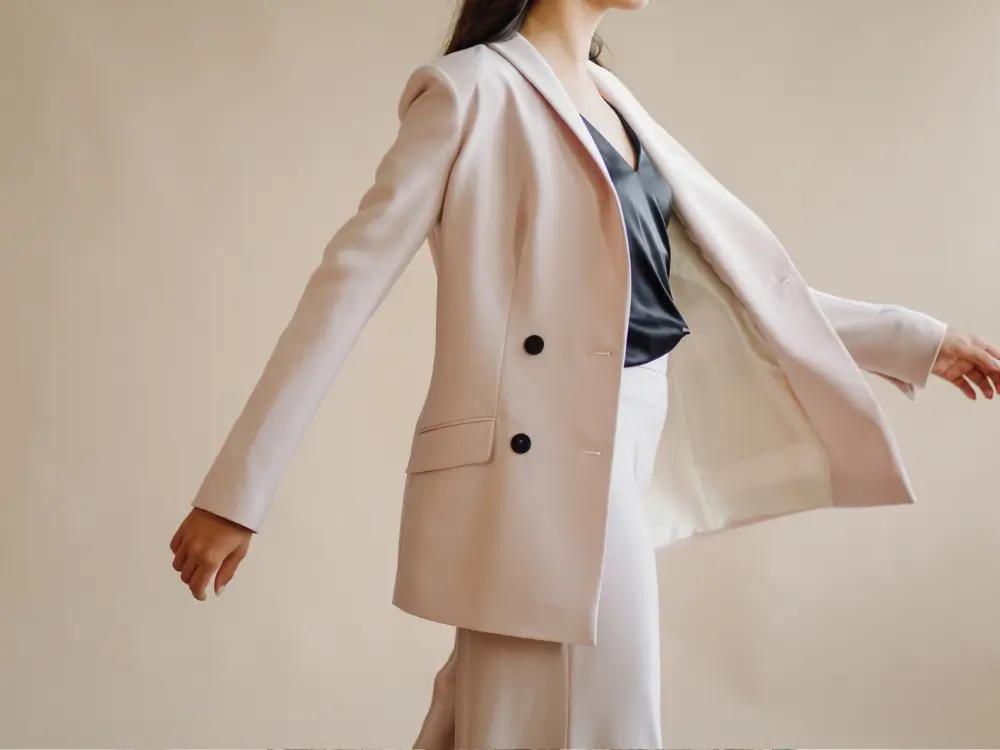 Mulher elegante com mais de 40 anos usando look atemporal com blazer e calça de alfaiataria"